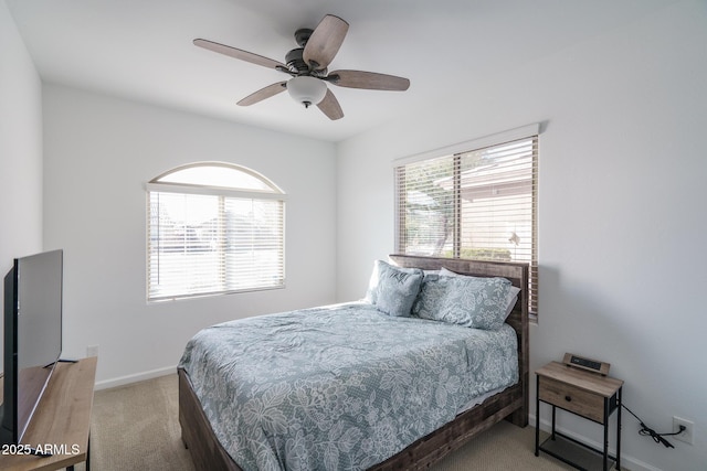 carpeted bedroom featuring ceiling fan and multiple windows