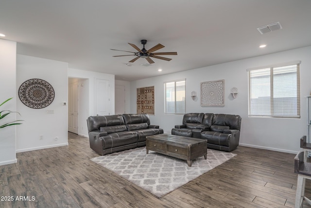 living room featuring a wealth of natural light, wood-type flooring, and ceiling fan