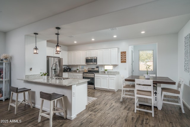 kitchen featuring white cabinetry, sink, stainless steel appliances, and kitchen peninsula