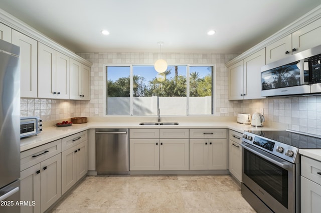 kitchen with stainless steel appliances, pendant lighting, tasteful backsplash, and sink