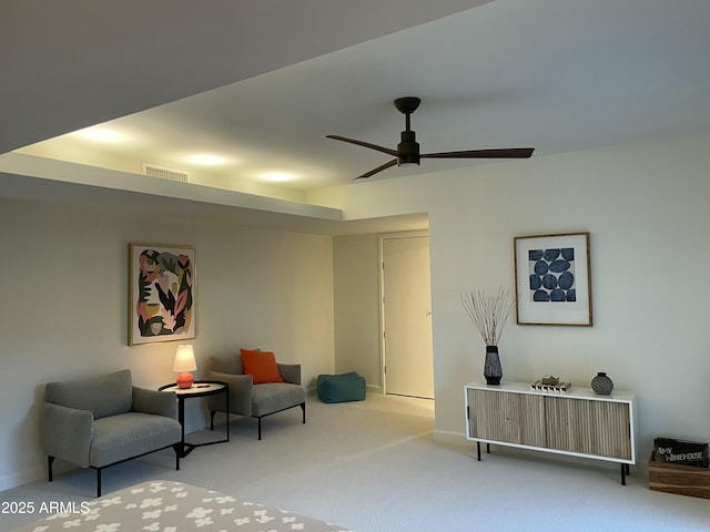 sitting room with ceiling fan and light colored carpet