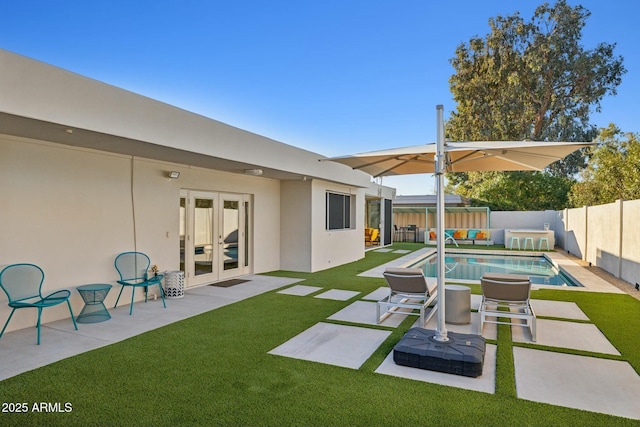 view of swimming pool featuring french doors, a lawn, and a patio