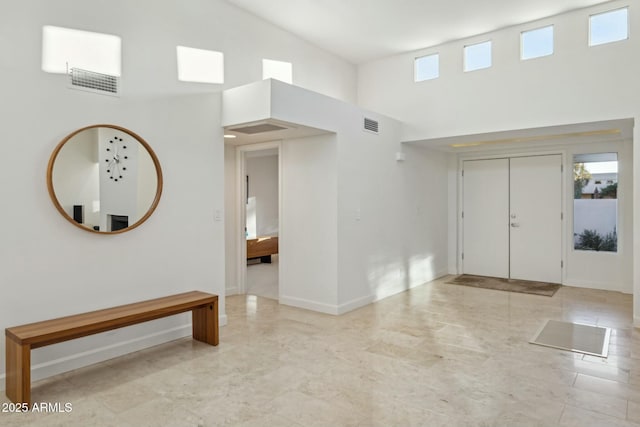 entryway with a towering ceiling and plenty of natural light