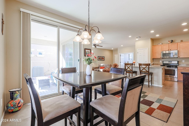 tiled dining room featuring ceiling fan with notable chandelier