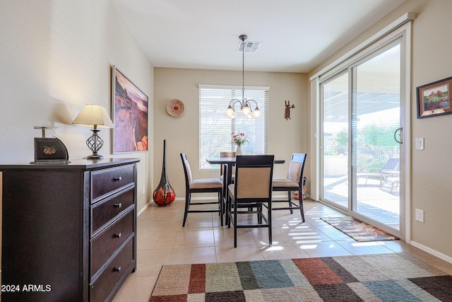 tiled dining room featuring a chandelier