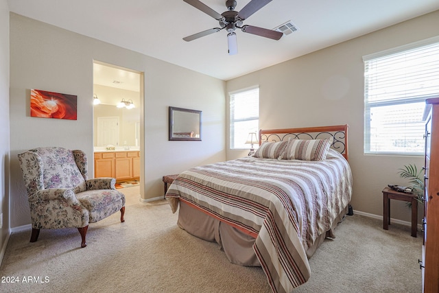 bedroom with ensuite bathroom, ceiling fan, and light colored carpet