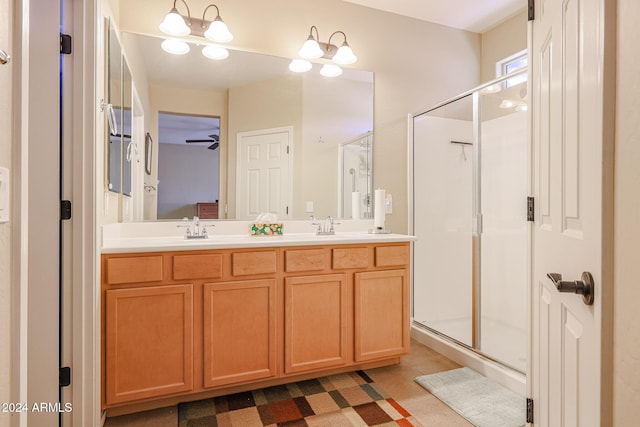 bathroom featuring vanity, ceiling fan with notable chandelier, and a shower with door