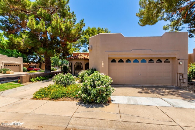 4135 E Altadena Ave, Phoenix, AZ 85028 - pueblo-style house with stucco siding, driveway, an attached garage, and a tile roof