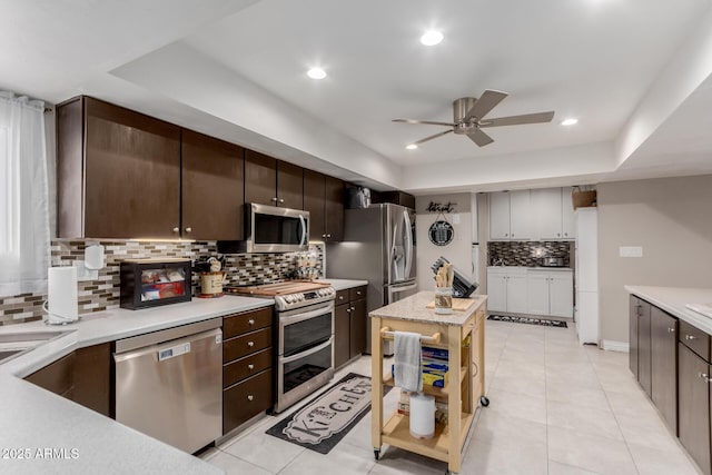 14001 N 34th Dr, Phoenix, AZ 85053 - kitchen featuring stainless steel appliances, a ceiling fan, backsplash, dark brown cabinets, and light tile patterned flooring
