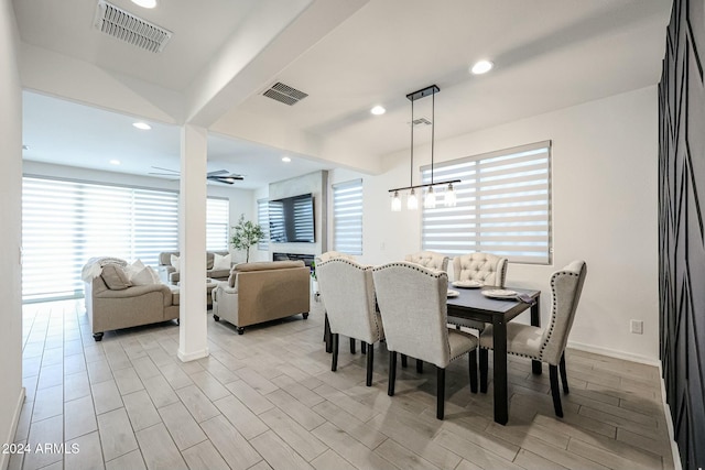 dining space featuring ceiling fan with notable chandelier and light wood-type flooring