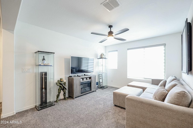 living room with ceiling fan, a fireplace, and light carpet