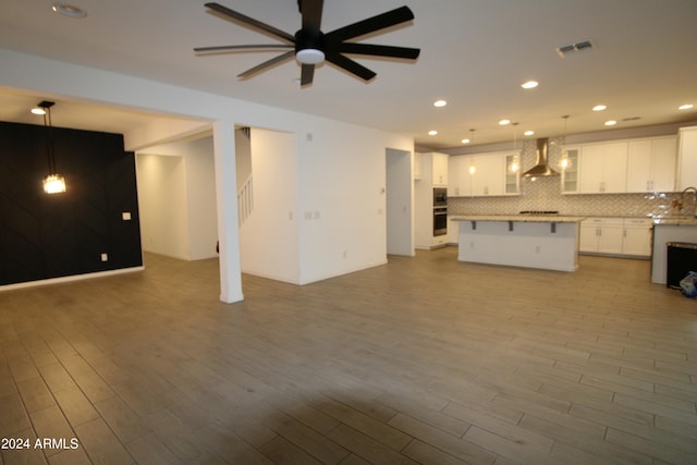 unfurnished living room with ceiling fan and light wood-type flooring