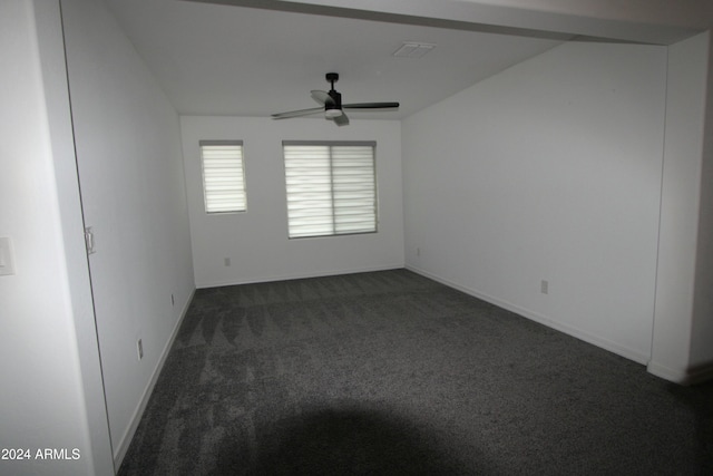 spare room with dark colored carpet and ceiling fan