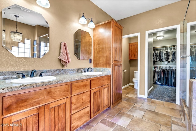 2699 E Claxton Rd, Gilbert, AZ 85297 - full bath featuring double vanity, a chandelier, stone finish floors, and a spacious closet