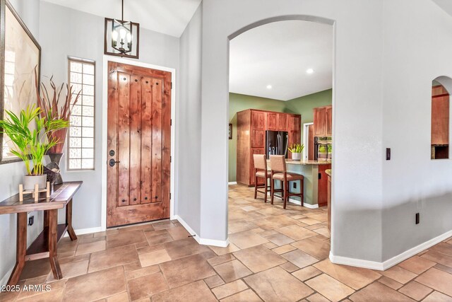 2699 E Claxton Rd, Gilbert, AZ 85297 - foyer featuring arched walkways, light stone finish floors, and a chandelier