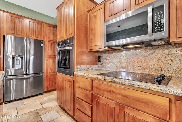 2699 E Claxton Rd, Gilbert, AZ 85297 - kitchen featuring appliances with stainless steel finishes, backsplash, light stone countertops, brown cabinetry, and stone finish floors