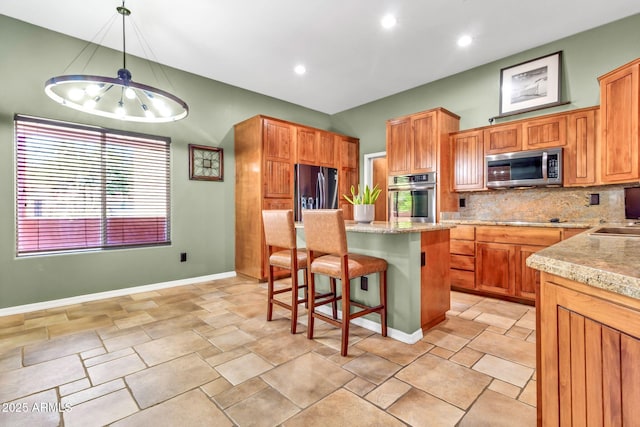 2699 E Claxton Rd, Gilbert, AZ 85297 - kitchen featuring stainless steel appliances, tasteful backsplash, a kitchen breakfast bar, a center island, and hanging light fixtures
