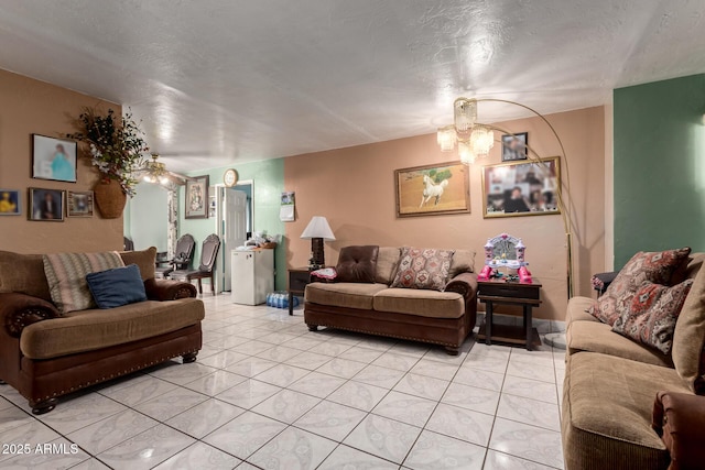 living room with a chandelier, light tile patterned floors, and a textured ceiling