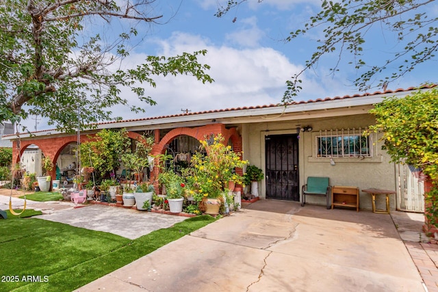 mediterranean / spanish-style house featuring stucco siding and a patio area