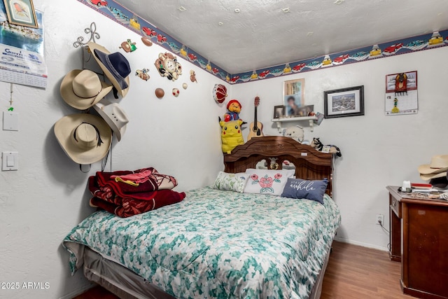 bedroom featuring wood finished floors and baseboards