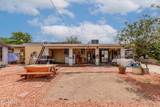 rear view of property with a patio, central air condition unit, and stucco siding