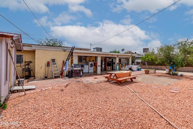 rear view of property with independent washer and dryer, stucco siding, and a patio area