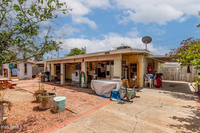 back of house with fence, a patio area, and an outdoor structure