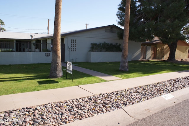 ranch-style home with a front lawn