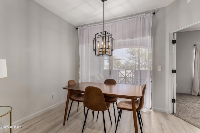 7936 E Wilshire Dr Unit 205, Scottsdale, AZ 85257 - dining area featuring light wood finished floors, an inviting chandelier, and baseboards
