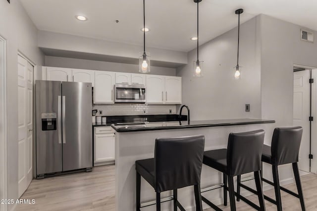7936 E Wilshire Dr Unit 205, Scottsdale, AZ 85257 - kitchen with tasteful backsplash, visible vents, dark countertops, light wood-type flooring, and appliances with stainless steel finishes