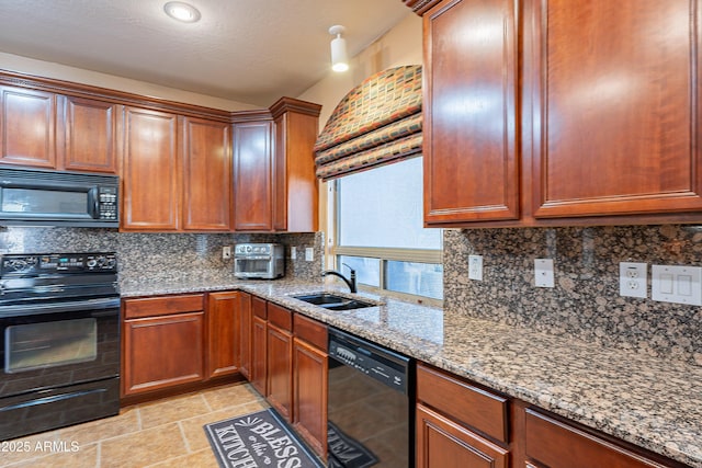 kitchen featuring black appliances, light stone counters, sink, and tasteful backsplash