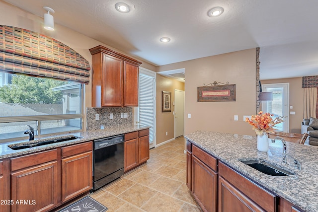 kitchen with decorative backsplash, sink, light stone counters, and black dishwasher