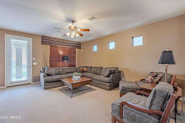 living room featuring ceiling fan, light colored carpet, and plenty of natural light