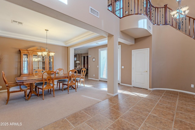 dining space featuring carpet, a high ceiling, and an inviting chandelier