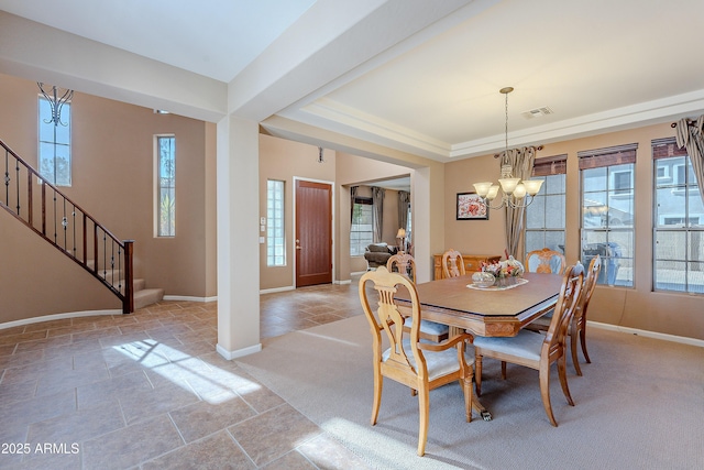 dining room with a raised ceiling and a notable chandelier