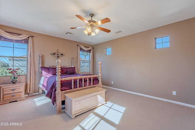 bedroom with ceiling fan, light carpet, and multiple windows