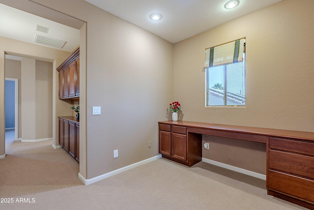 unfurnished office with light carpet and built in desk