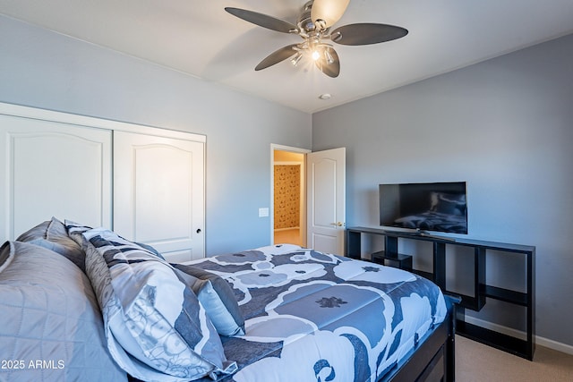 carpeted bedroom with ceiling fan and a closet