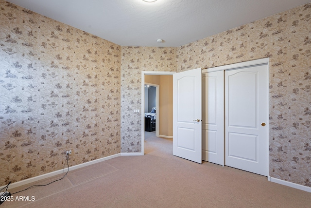 unfurnished bedroom featuring carpet flooring and a closet