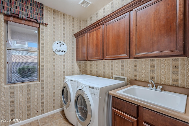 washroom featuring separate washer and dryer, sink, light tile patterned floors, and cabinets