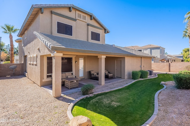 back of house featuring a yard, an outdoor living space, and a patio area