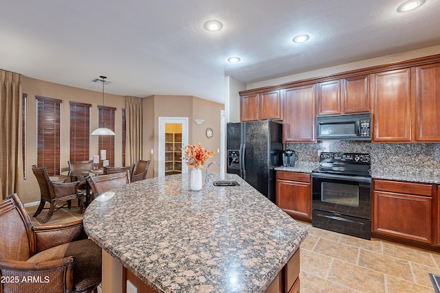 kitchen with decorative backsplash, a kitchen island with sink, sink, black appliances, and pendant lighting