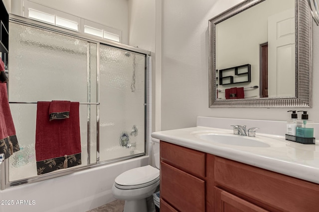 full bathroom with enclosed tub / shower combo, vanity, and toilet