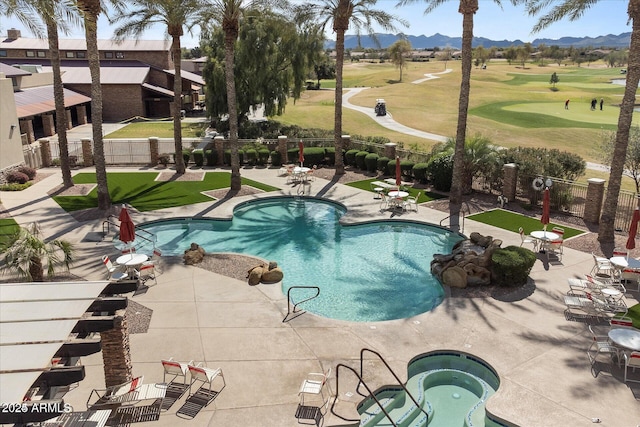 view of pool featuring a hot tub, a mountain view, and a patio