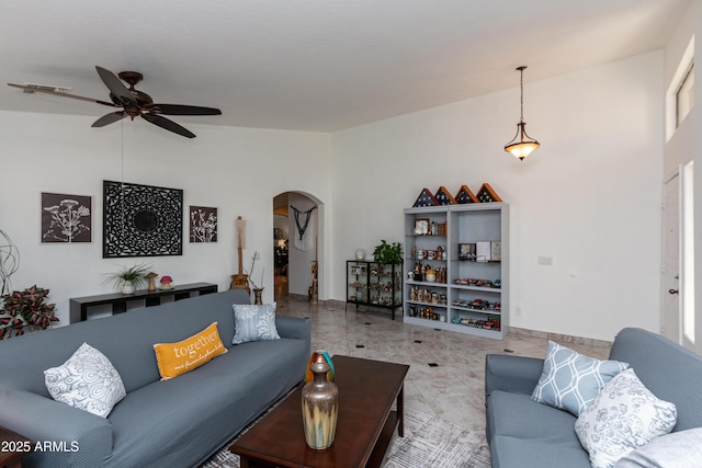 living area featuring arched walkways, vaulted ceiling, visible vents, and ceiling fan