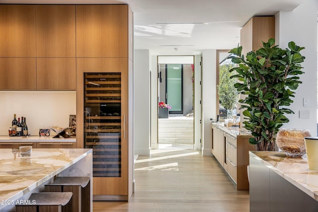 interior space with wine cooler and light hardwood / wood-style flooring