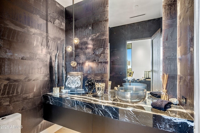 bathroom with tile walls, sink, and toilet