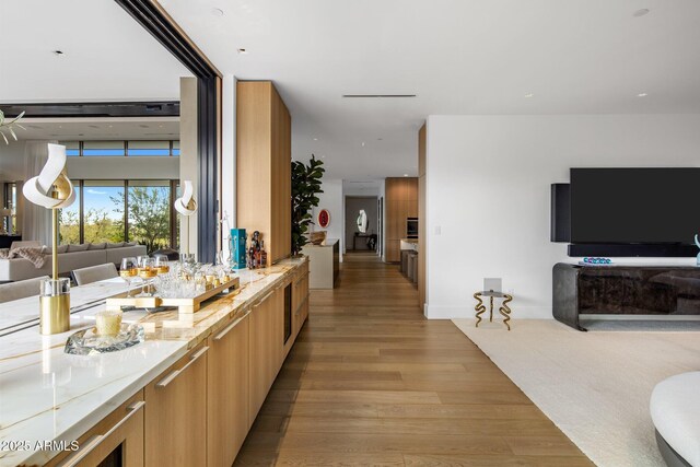 interior space with light stone counters and light hardwood / wood-style floors