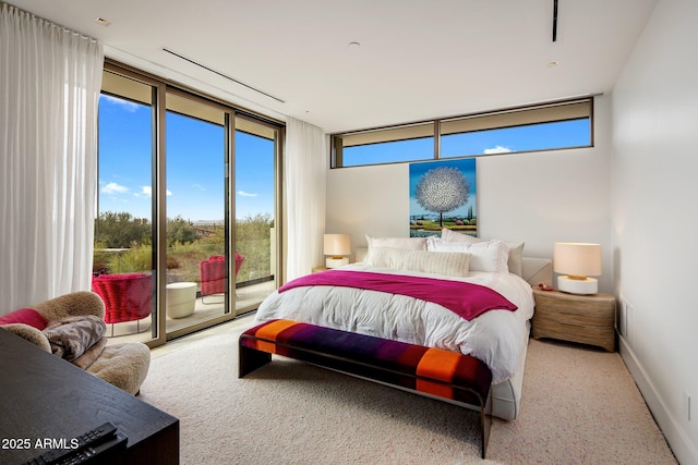 bedroom with expansive windows and access to outside