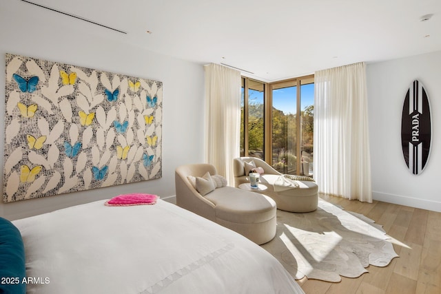 bedroom featuring hardwood / wood-style flooring and a wall of windows